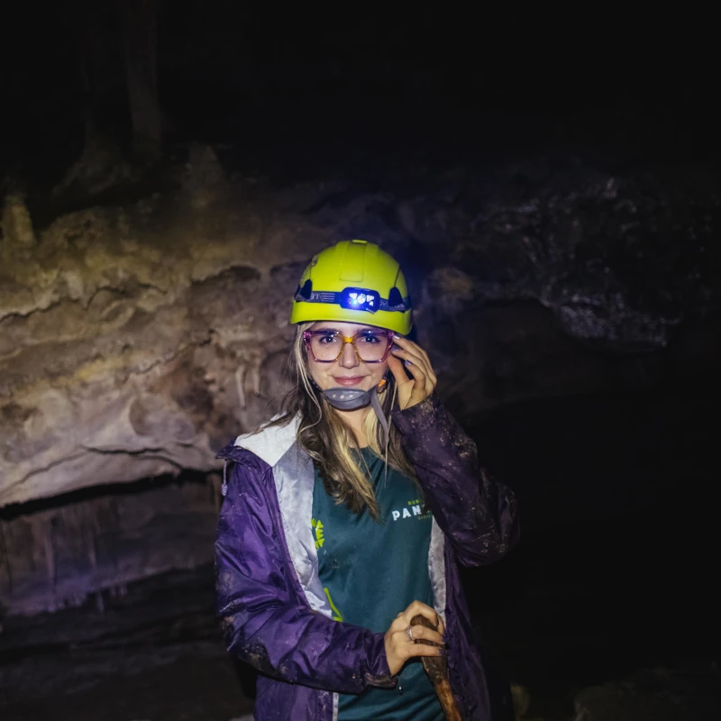 Visitante explorando una cueva junto a un guía